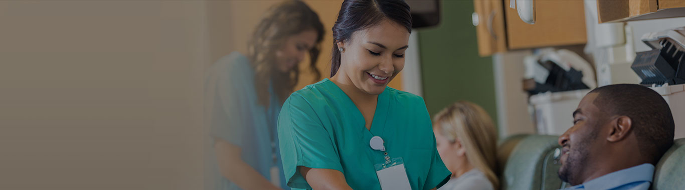 A Phlebotomists drawing blood from her patient