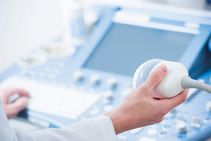 A radiologist holding an ultrasound scanner