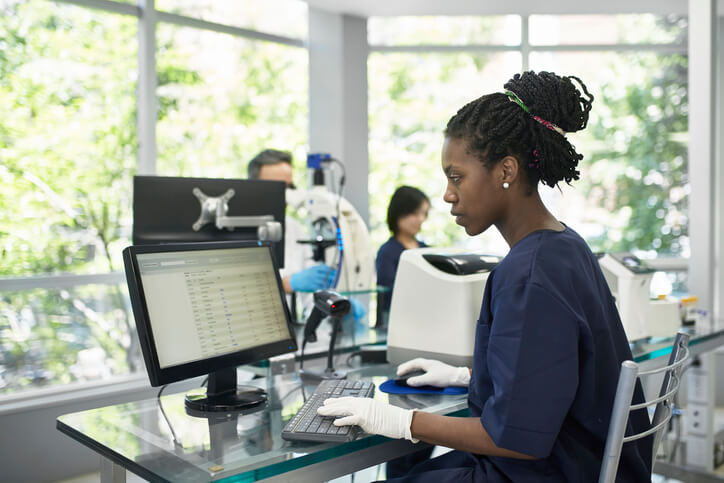 Medical technician working on computer in lab