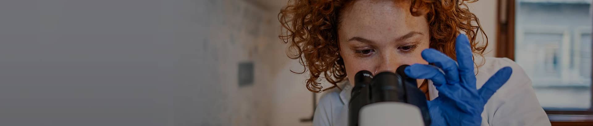 Nurse looking into a microscope 