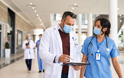 Two clinicians conversing in a medical hospital hallway Two clinicians conversing in a medical hospital hallway