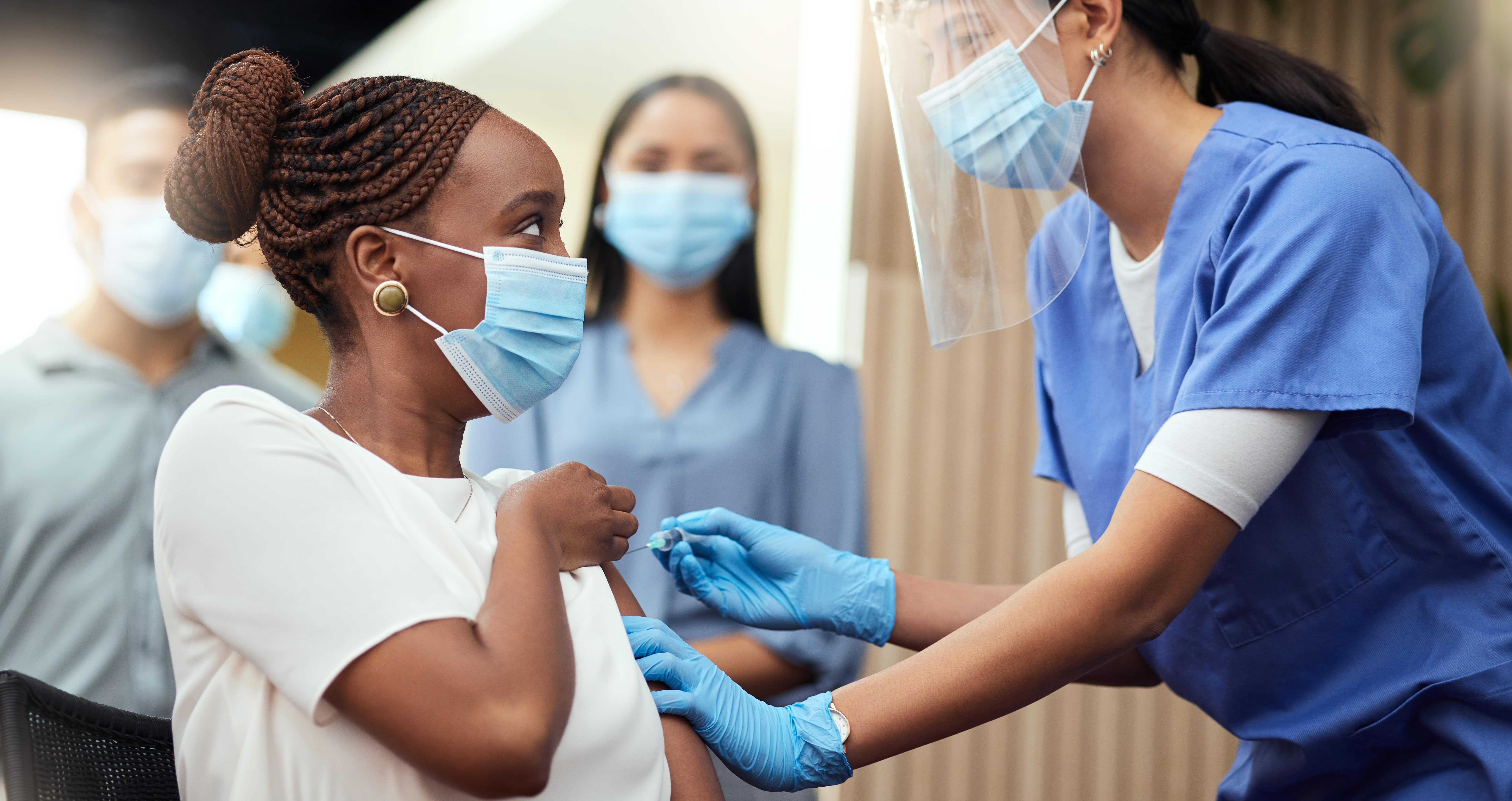 nurse providing patient with COVID vaccine