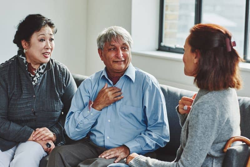Female caregiver treating senior couple 