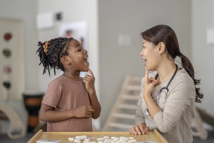 Therapist guiding young patient through speech therapy