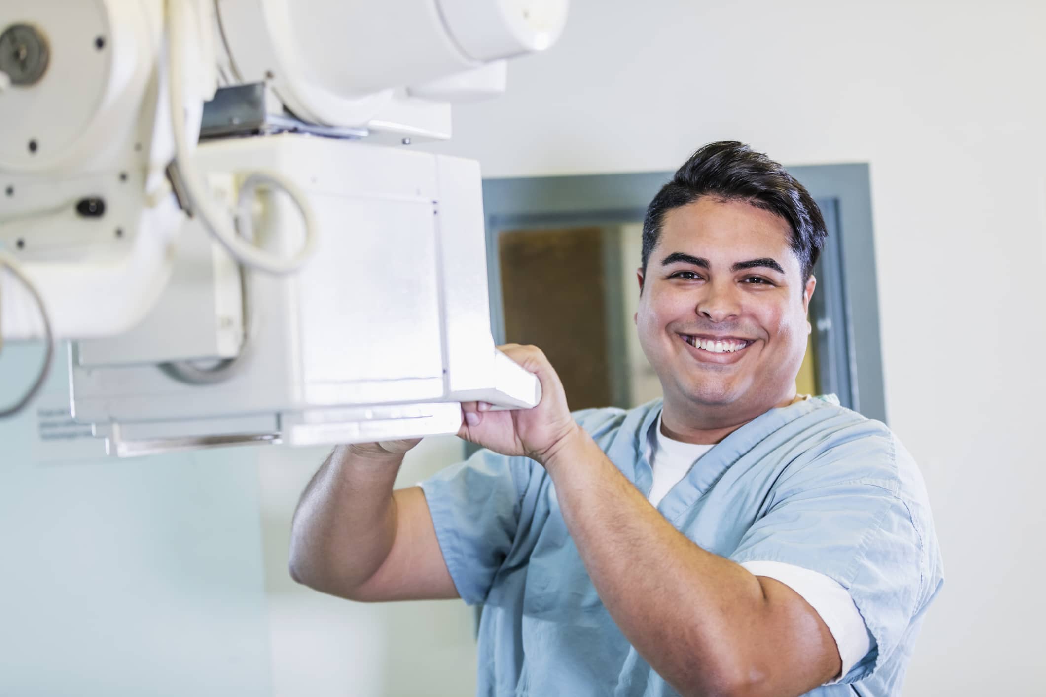 Radiology Tech Smiling while holding an x ray machine