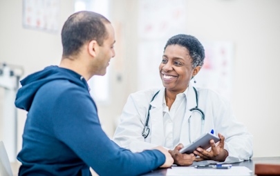 a physician smiling at a patient a physician smiling at a patient