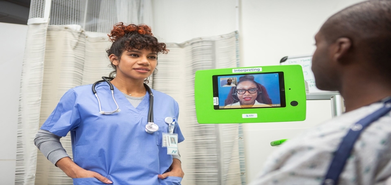 A nurse engaging with a patient through a video screen