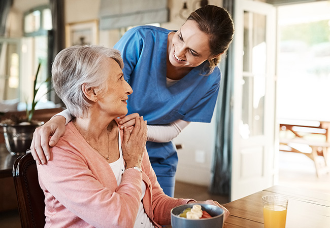 Home health nurse putting hands on patient's shoulders