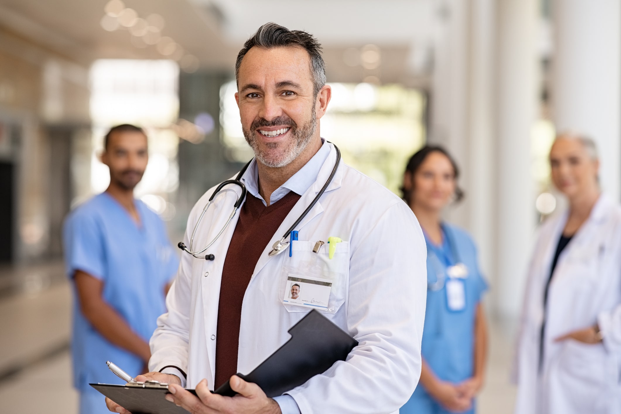 smiling doctor and supporting medical staff