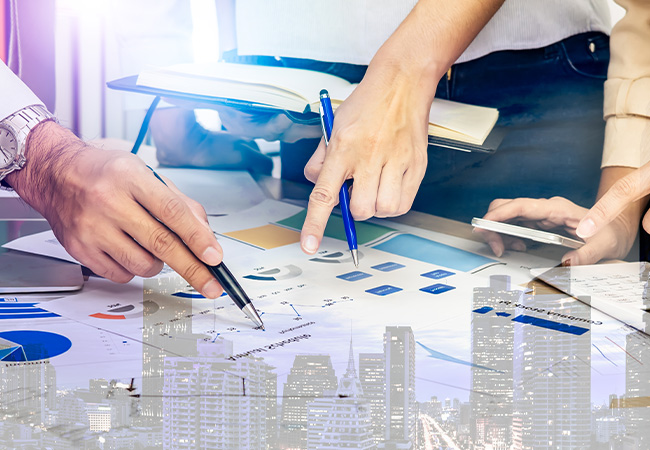 People pointing at papers with charts and graphs